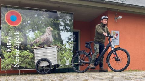 Ranger Lars de Wilde mit einem der zwei neuen Info-Fahrräder vor der Nationalparkinformation in Schwarzenhof