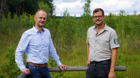 Axel Schümann (Güstrower Schlossquell) und Eike Lucas (Müritz-Nationalpark) auf dem Moorsteg im Serrahn. So wie hier soll es auf der Steinstückenwiese bald auch wieder aussehen.